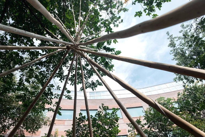 Photo shows a Tipi underneath a blue sky. 