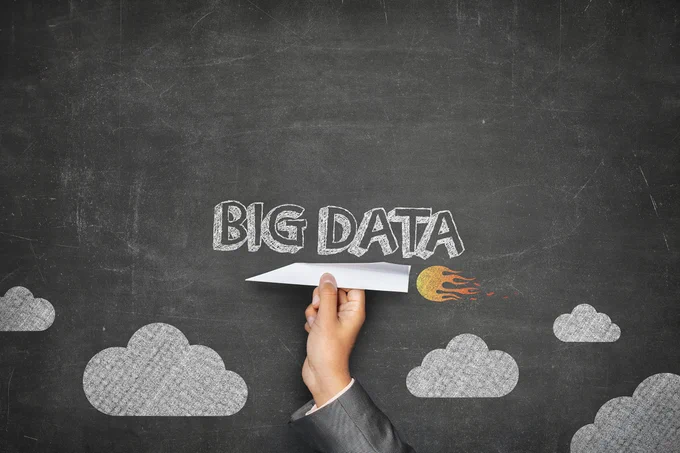 Foto: Hand hält einen Papierflieger vor einem Hintergrund mit dem Text "Big Data"; Copyiright: PantherMedia/info@crashmedia.fi