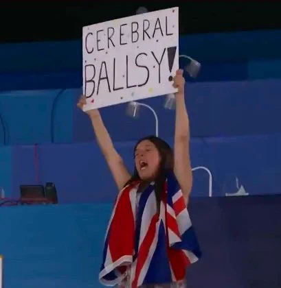 Rosie Jones holds up a banner saying Cerebral Ballsy at Tokyo 2020