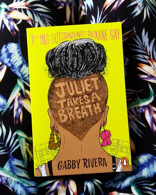 Picture of the book Juliet takes a breath on a black background with blue feathers.