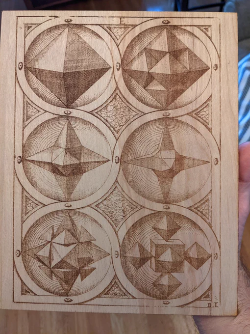 A laser engraved piece of wood with depictions of mathematical solids