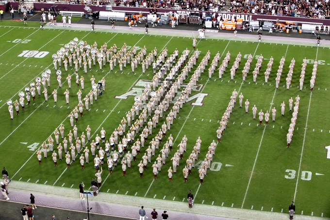 the aggie band forming the tamu logo at midfield during their performance