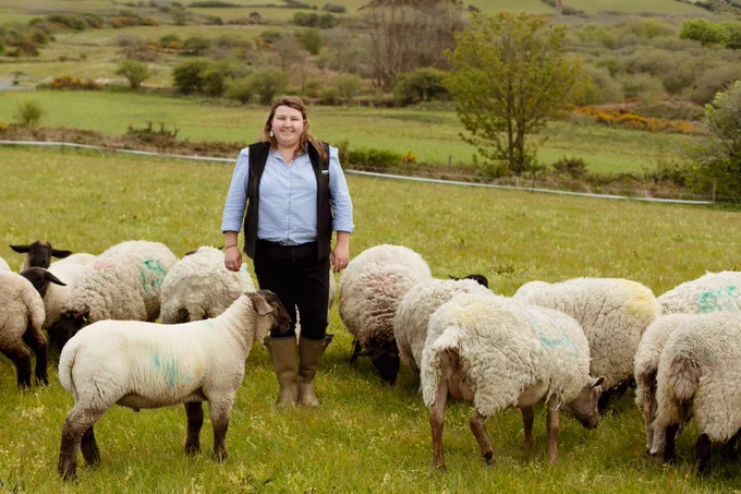 Cornwall YFC Chair Rachael Benney in a field with sheep