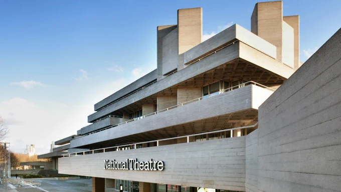 Concrete layered brutalist building in sunshine with National Theatre written across it.