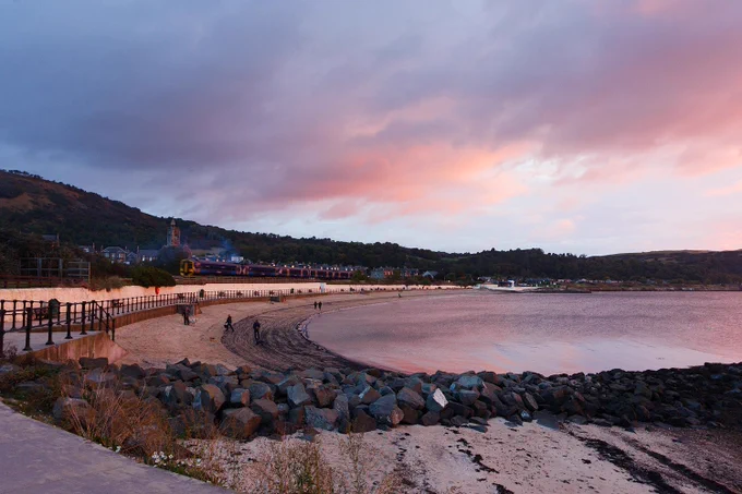 Burntisland beach sunrise, with train passing through and some pink clouds