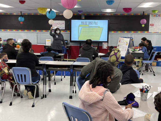 Group of parents at desks in a classroom
