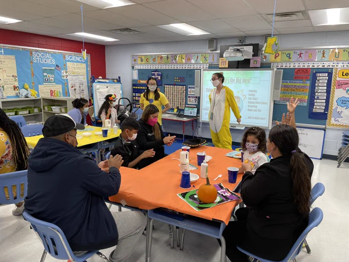 Group of families at desks in a classroom