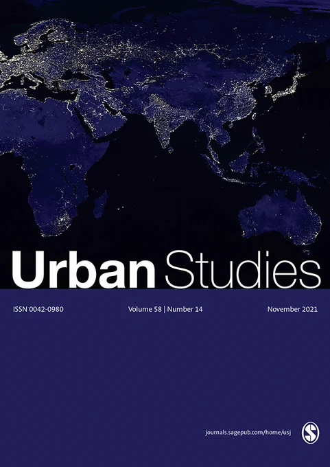 Urban Studies Journal  cover for November 2021 issue. White heading text reads 'Urban Studies' and issue details are listed in fine text a banner below. Background is a map of the world at night with illuminated lights.