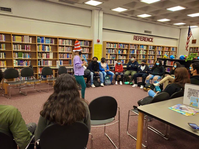 Librarian Ms. Neal reads a story book to the class while wearing a Cat in the Hat hat