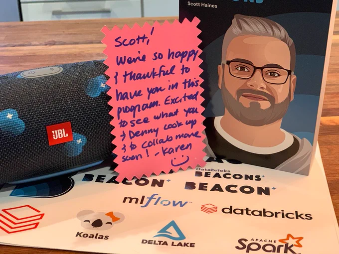 A hand written note, customized speaker, and wood cutout of my face, and a sticker sheet with Apache Spark related stickers