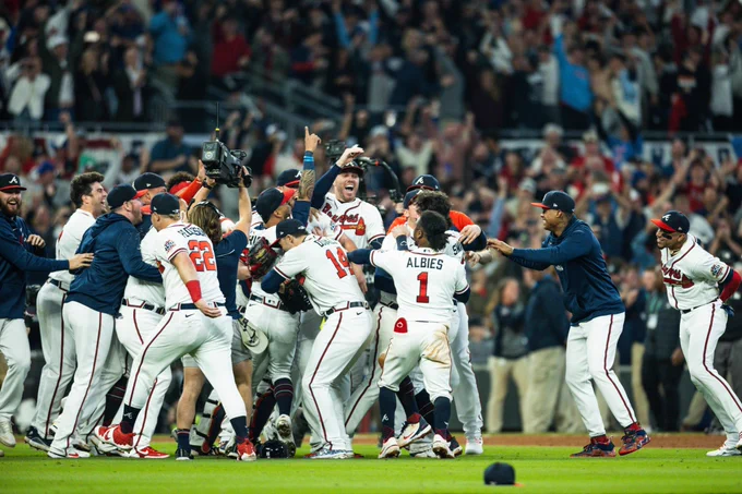 The Braves celebrate their NL title while jumping Up and down and meeting in the infield at Truist Park.