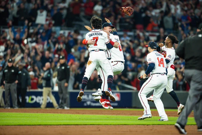 The Braves celebrate their NL title while jumping Up and down and meeting in the infield at Truist Park.