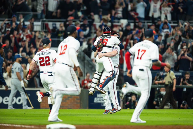 The Braves celebrate their NL title while jumping Up and down and meeting in the infield at Truist Park.