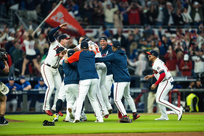 The Braves celebrate their NL title while jumping Up and down and meeting in the infield at Truist Park.