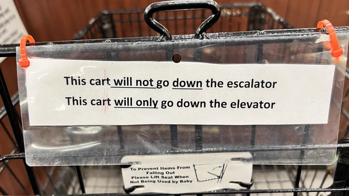 A sign that says “this cart will not go down the escalator. This cart will only go down the elevator.”