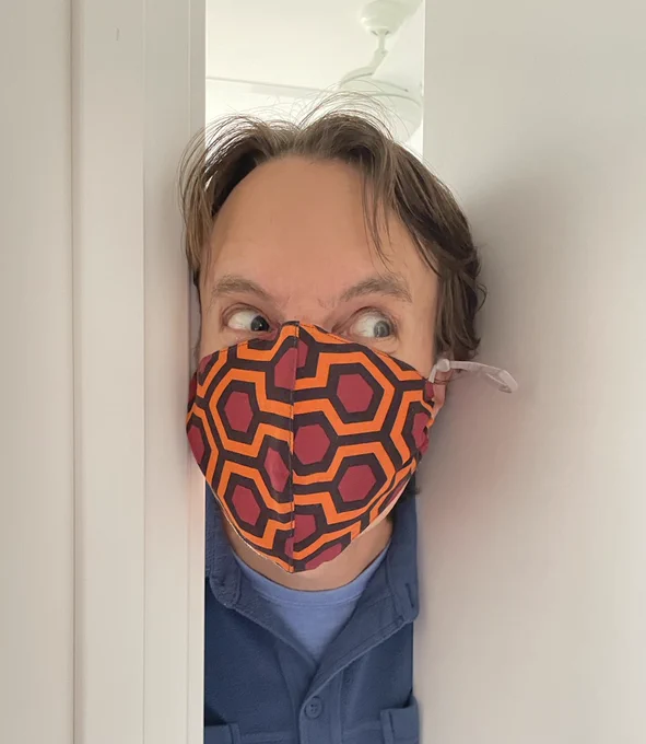 Man wearing a mask with a pattern from The Shining. Imitating a scene from the movie