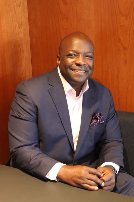 Cordell Carter, II Esq. sits in a booth smiling