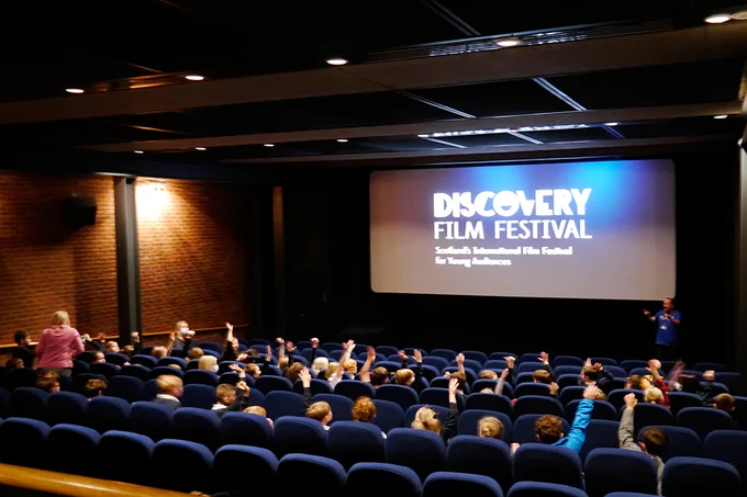 Pupils from Errol Primary with their hands up in DCA cinema