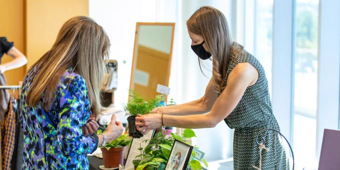 The Plant House owner, Kari Carpenter, explains the care and needs of her plant products to an attendee.