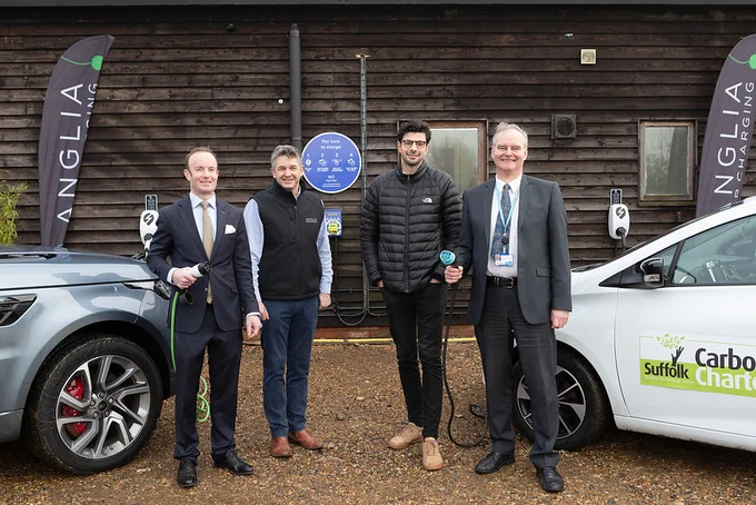 Councillor Richard Rout, Richard Seppings (Anglia Car Charging), Charlie Jardine (EO Charging), Peter Frost (Suffolk County Council) standing in front of newly installed charging points and electric vehicles.
