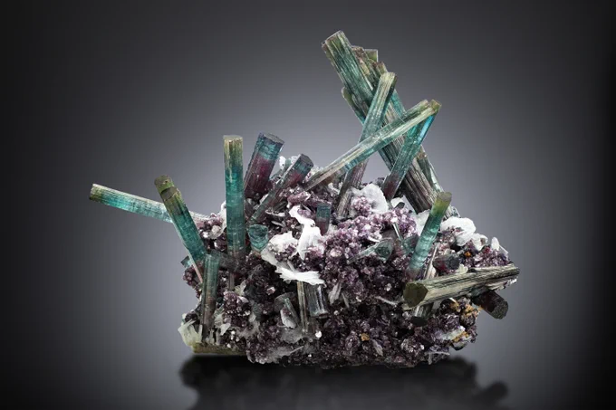 Elbaite with Lepidolite and Albite placed on a black background.
