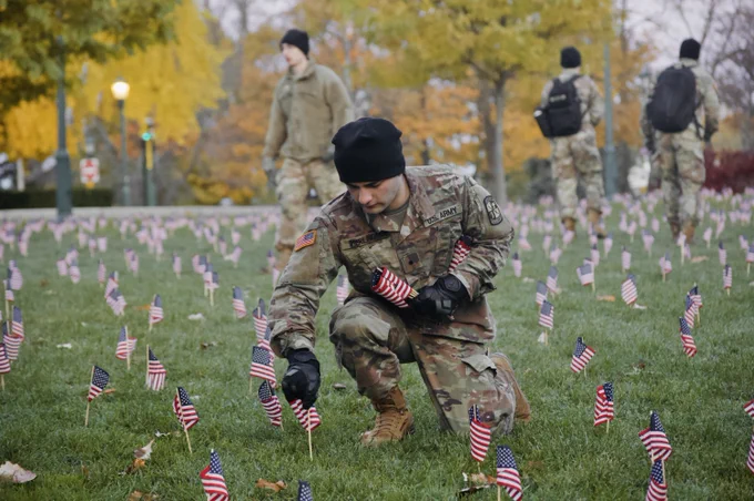 UVM ROTC cadet places an American flag in the Davis Center Green