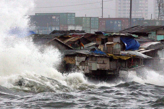 Squatters’ shanties along the sea wall of Vitas Tondo (Manila, Philippines) endure big waves produced by strong winds brought about by Typhoon Kiko/Chanthu. 