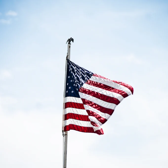 U.S. flag on pole with sky in background