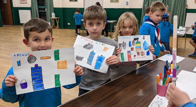 Four Beaver Scouts proudly showing their newly created posters all about recycling.