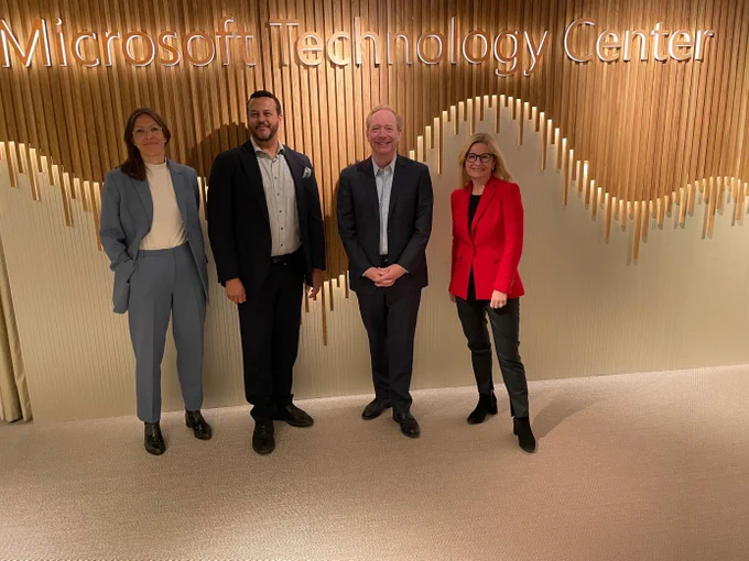 Medarbetare ler framför Microsoft Technology Center.