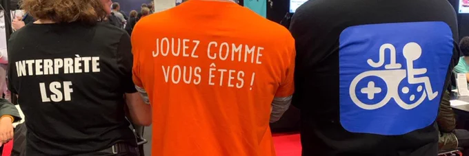 3 personnes de dos avec 3 tshirts imprimés différents : "interprète LSF", "jouez comme vous êtes" et un logo représentant une personne en fauteuil roulant assis sur une manette de jeu, en blanc sur fond bleu