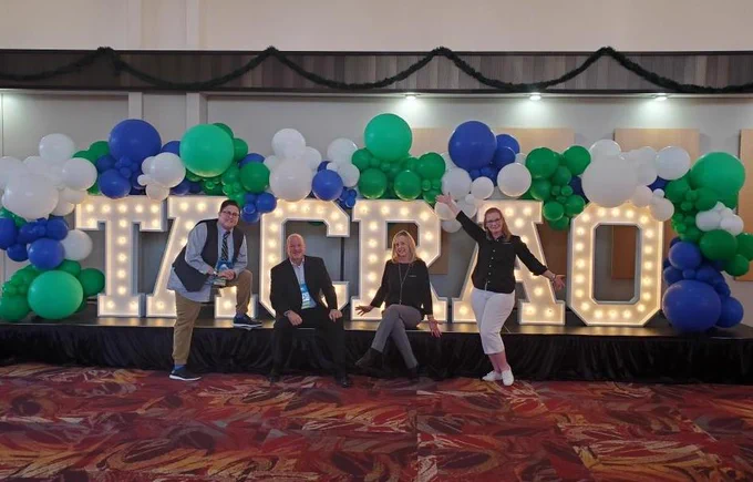 Having fun posing in front of the TACRAO sign.
