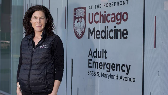 Dr. Keegan Checkett standing outside of the adult emergency enterance at UChicago Medicine.