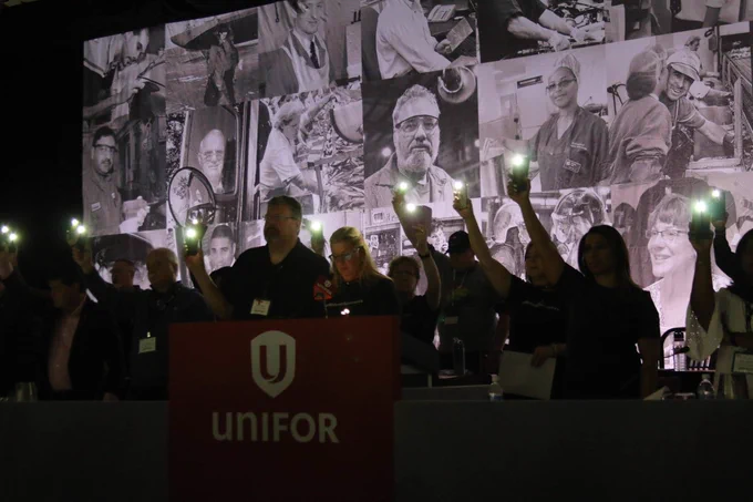 People holding lights at a Unifor vigil.