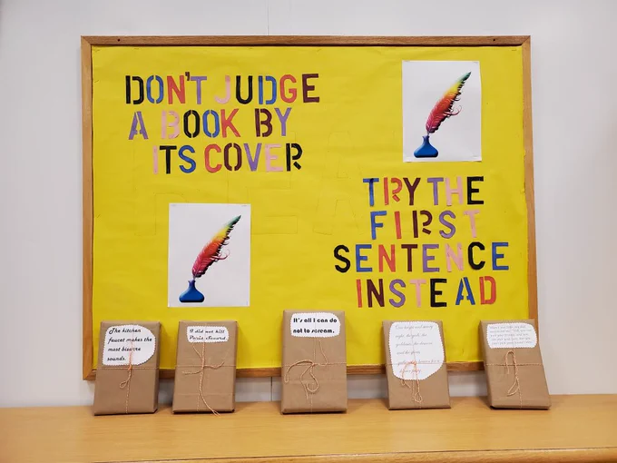 Bulletin board that reads Don’t judge a book by its cover, try the first sentence instead. In front of the bulletin board is a line of five books individually wrapped in paper with their first lines printed on the front.