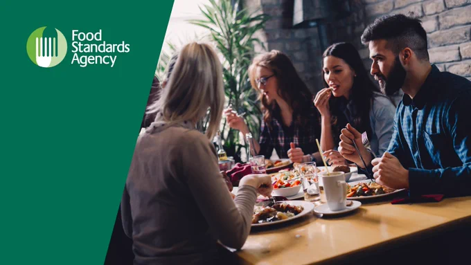 People eating food around a table in a restaurant.