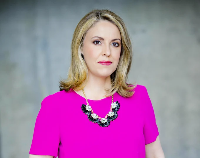 Sarah Smith is looking into the camera wearing a pink top