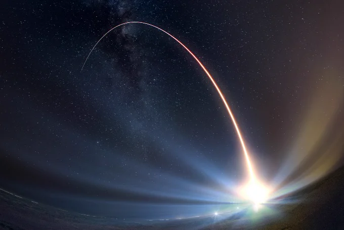 A trail of light from a missile streaking through the sky.