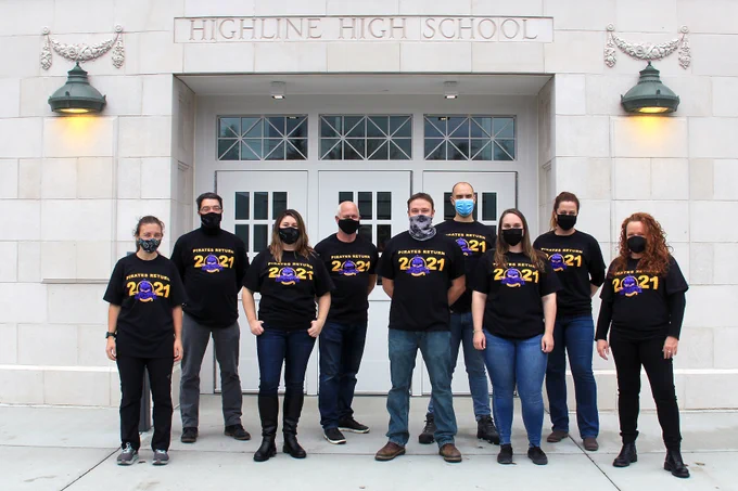 Bassetti & Skanska staff members pose in new tshirts in front of HHS.
