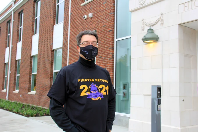 Bassetti Principal Architect Dan Miles poses in front of HHS in new tshirts.