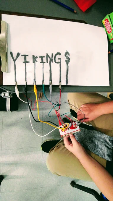 Makey Makey connected to a white paper and graphite 'controller' with letters spelling out VIKINGS