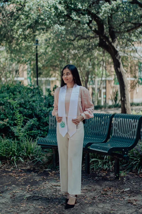 Zarrin poses on campus wearing her honors stole.