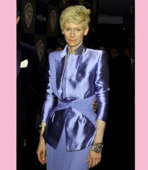 Renowned actress Tilda Swinton wearing an angular periwinkle shirt and skirt.