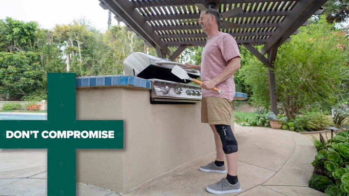 Text in green   symbol "Don't Compromise"
Image: Man wearing OA Knee Brace at a BBQ grill 