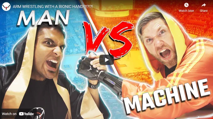 screenshot of youtube video of arm wrestling. graphic says: man vs machine