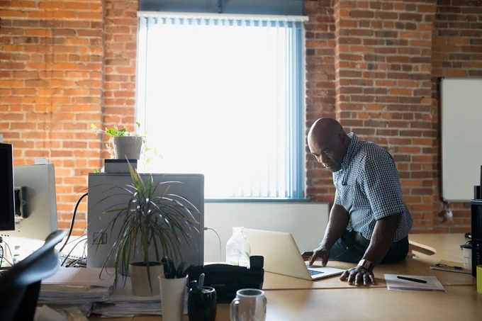Man looking at laptop in office 