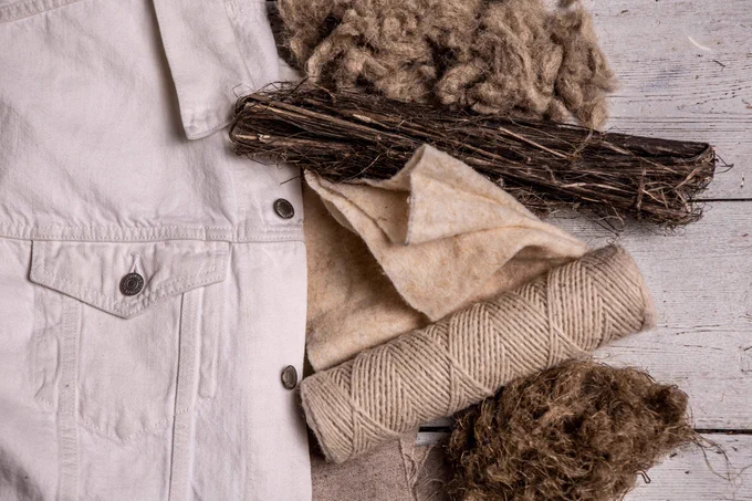 A cream denim-style jacket along with yarn and hemp at different stages of processing
