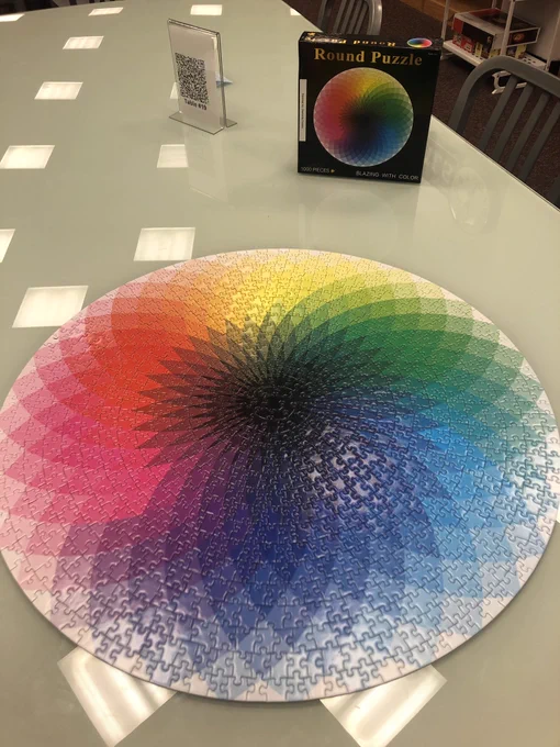 A completed round puzzle of 1000 pieces that displays the color spectrum