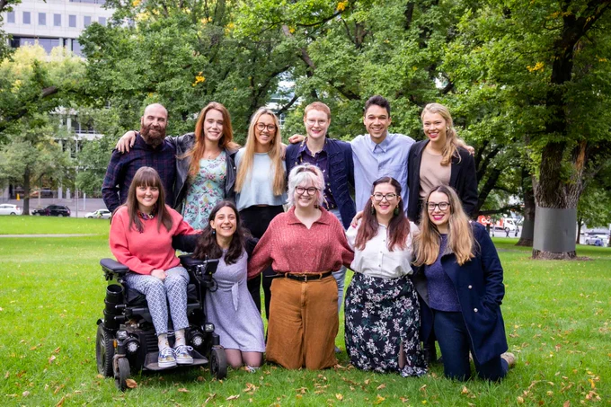 YDAS team photo with 11 people smiling at the camera in a park.