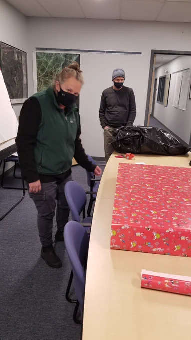 Two people wrapping Christmas presents.